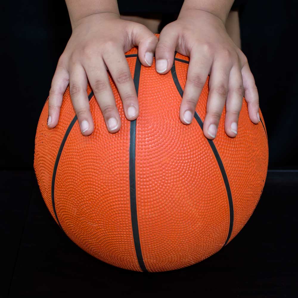 Girl with hands on basketball